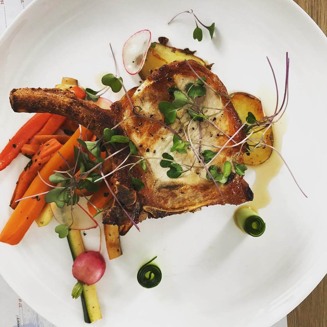 Elegancko podane danie z mięsem i warzywami na białym talerzu